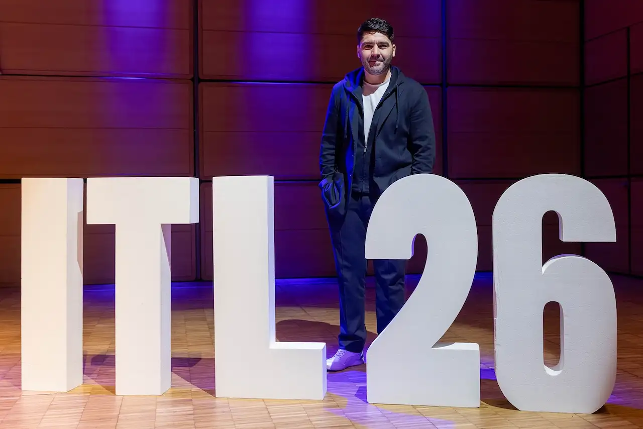A guest standing behind the ITL 26 letters